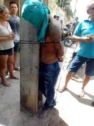 Após roubar celulares, homem é capturado pela população e amarrado em poste