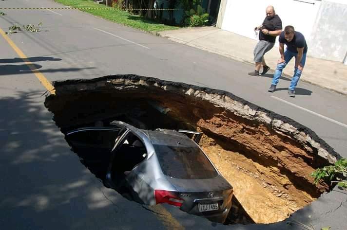 Carro cai dentro de cratera em rua que cedeu no RS