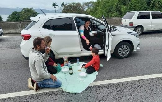 Família faz piquenique fora do carro durante congestionamento na BR-101