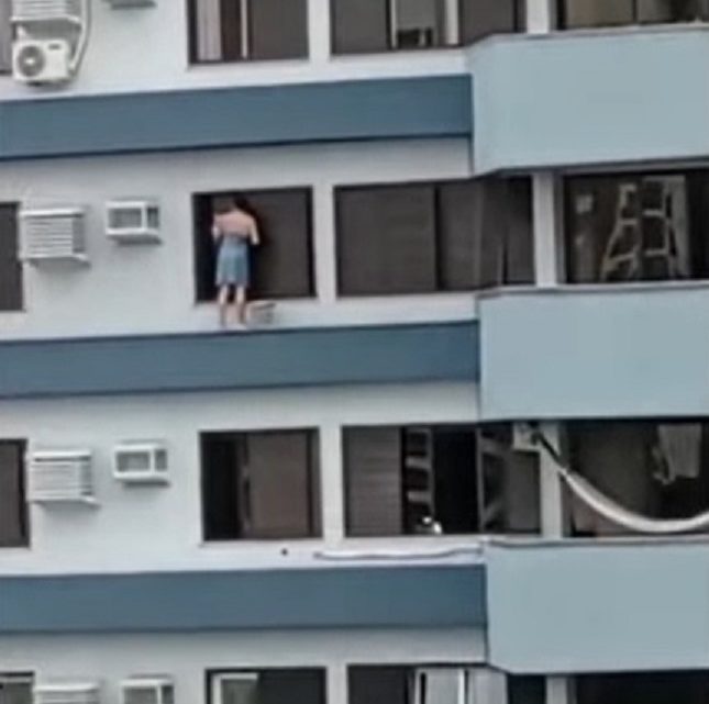 Vídeo: moradora se pendura em prédio para limpar janela em SC