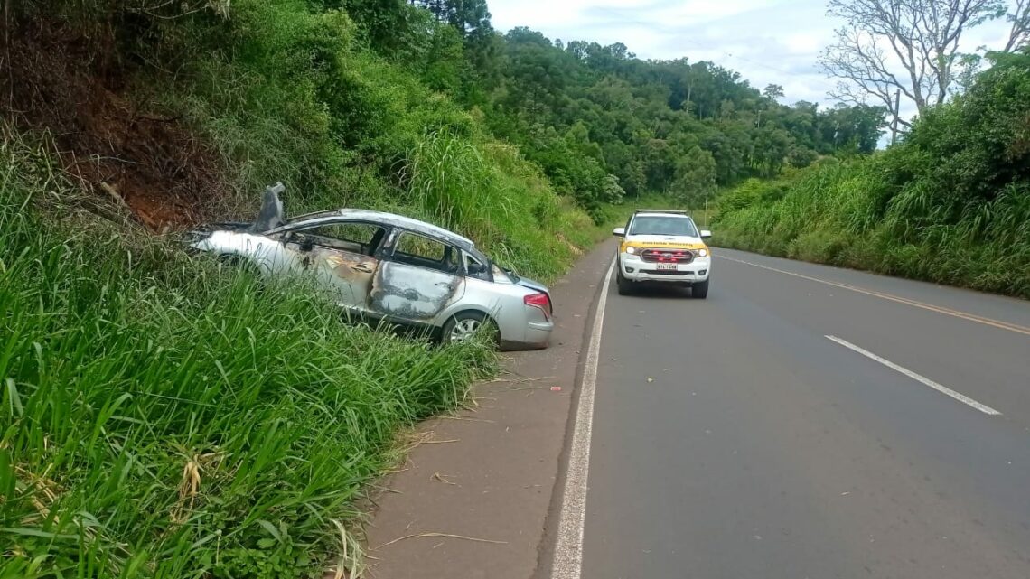 Carro com placas de Chapecó sai da pista, colide em barranco, pega fogo e deixa 3 pessoas feridas na SC 157