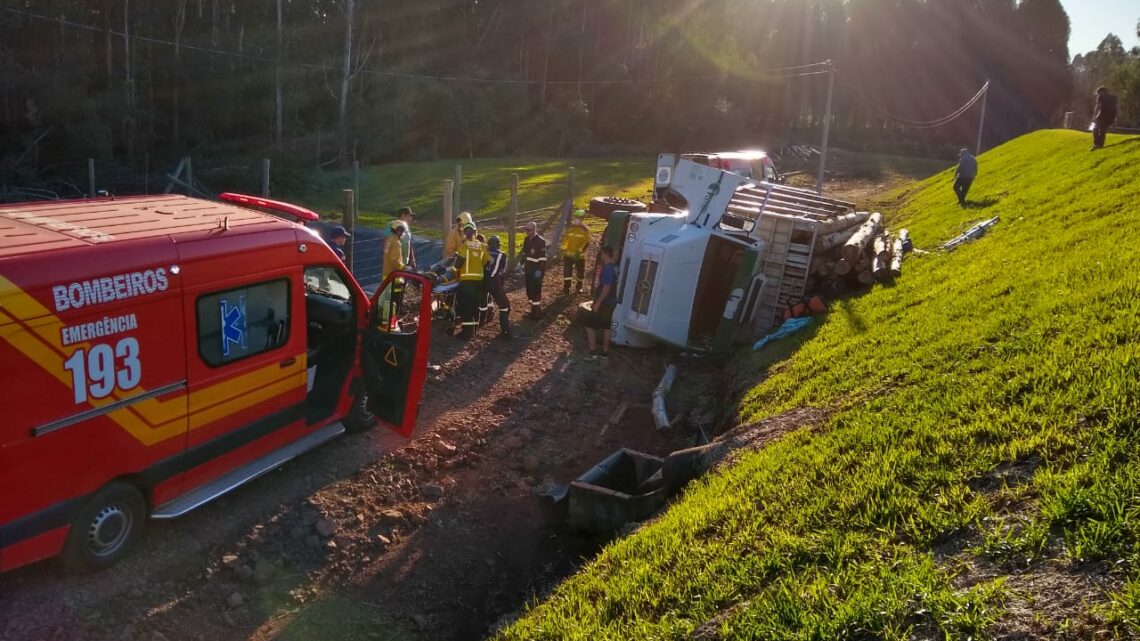 Caminhão carregado com toras de madeira tomba e deixa motorista ferido na SC 480 em Chapecó